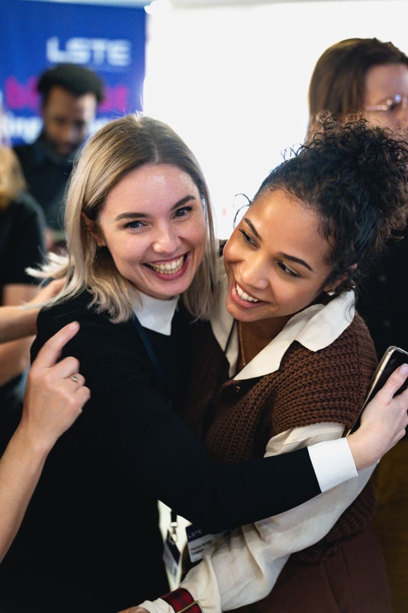 Two attendees sharing a warm moment at LSTE 2025