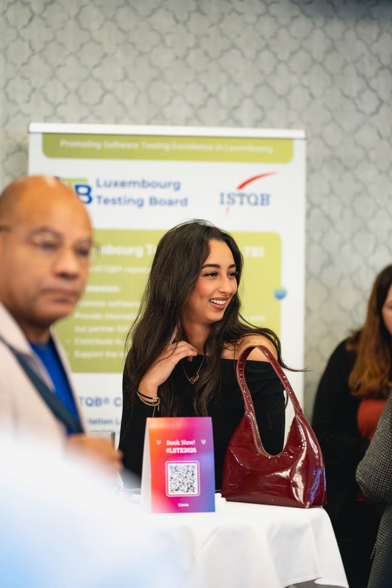 Attendees networking near the ISTQB booth at LSTE 2025